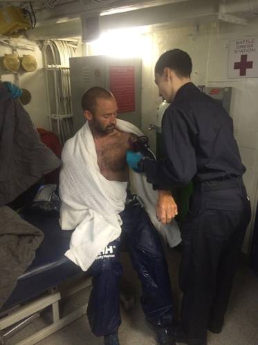 A rescued mariner has his vital signs checked in a battle dress station by a hospital corpsman aboard the aircraft carrier USS Dwight D. Eisenhower after his vessel became disabled off the coast of Florida. (U.S. Navy photo by John Osborne)