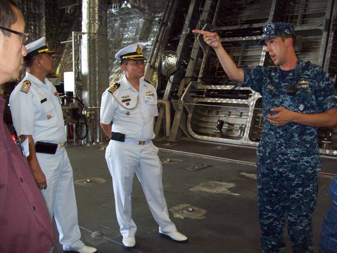 Cmdr. Dave Back (right), executive officer of USS Independence (LCS 2) Gold Crew, conducts a tour of his ship to attendees of the Sea Giraffe Users Group at Naval Base San Diego. He is seen here showing the ship’s spacious mission bay to Cam Fung from Canada (left), and Capt. Charlie Songsawangthus and Cmdr. Sarawoot Chiyangcabut from Thailand. (Photo by Papola Kani, Consulate of Sweden, San Diego)