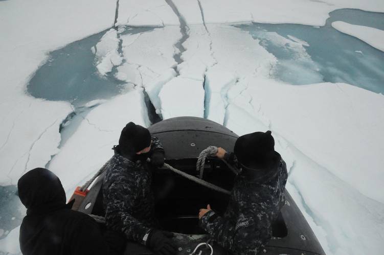 Sailors aboard the fast attack submarine USS Seawolf (SSN 21) inspect the boat after surfacing through Arctic ice. Seawolf conducted routine Arctic operations. (U.S. Navy photo/Released)