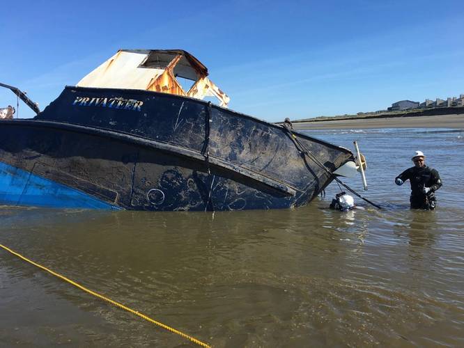 Salvage experts attach lines cables to the beached fishing vessel Privateer they prepare to attempt moving the vessel further ashore to expedite salvage operations near Ocean Shores, Wash., May 10, 2016. (U.S. Coast Guard photo by Bradley Bennett)