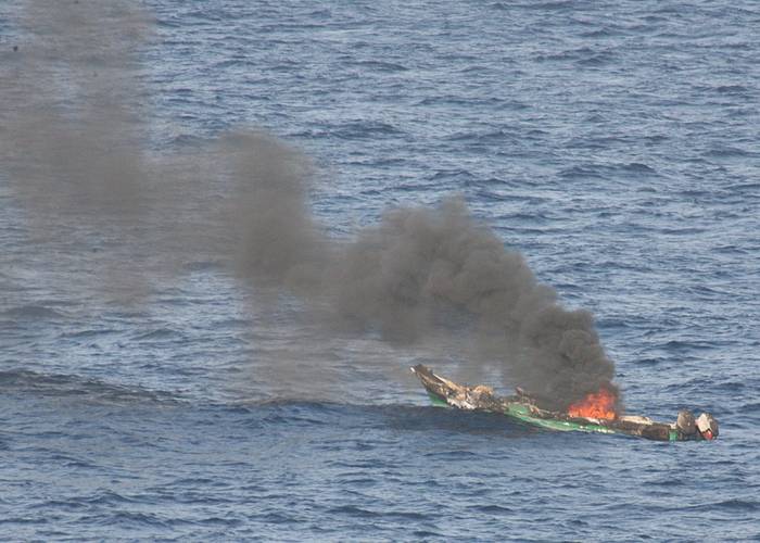 Suspected pirates skiff burns after being destroyed near the amphibious dock landing ship USS Ashland in 2010. (U.S. Navy photo/Harry J. Storms)