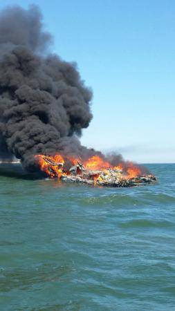 The Coast Guard rescued three people from the water after their boat caught fire near Shinnecock, N.Y. The fire engulfed the 36-foot cabin cruiser and the three people abandoned the vessel into the water to swim to their deployed life raft. (U.S. Coast Guard photo by Adam Long)