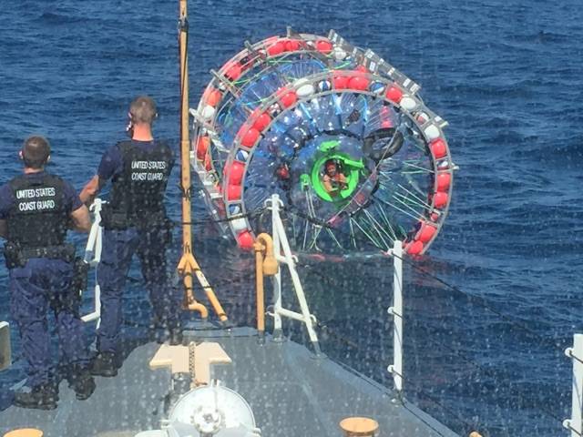 The crew of the Coast Guard Cutter Gannet speak with a man within a hydro pod off the coast of Jupiter, Florida, April 24, 2016. After speaking with the crew aboard the Gannet, Reza Baluchi agreed to end his voyage Bermuda and safely embarked the cutter. (U.S. Coast Guard photo)