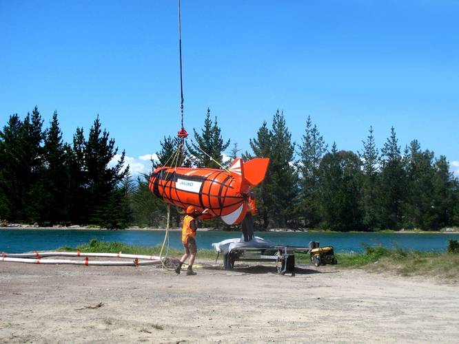 The ShipArrestor container is lifted by helicopter