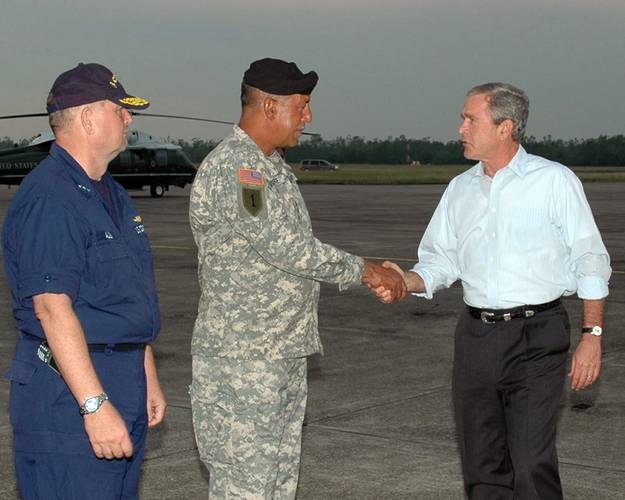 Then President George W. Bush (R) greets Commander, Joint Task Force Katrina, U.S. Army Lt. Gen. Russel Honore, and Director of FEMA Relief Efforts, U.S. Coast Guard Vice Adm. Thad W. Allen (L) as he steps off Air Force One on board Naval Air Station Joint Reserve Base, New Orleans, Oct. 10, 2005. U.S. Navy Photo