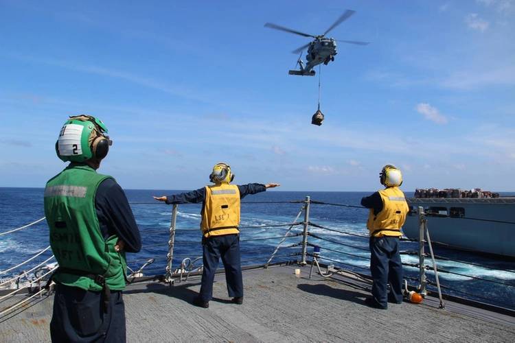 U.S. Navy Sailors use hand signals while directing helicopter operations aboard the Arleigh Burke-class guided-missile destroyer USS Kidd (DDG 100). Kidd is conducting search and rescue operations for the missing Malaysian Airlines flight MH370. (U.S. Navy photo by Karmowska-Brooks)