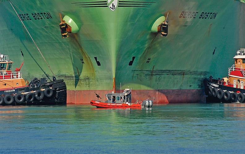 While providing a security perimeter, a Coast Guard 25-foot response boat is flanked by two tugs as the Liquid Natural Gas tanker Berge Boston is moored to the pier at an LNG facility here. USCG photo by PA2 Luke Pinneo