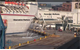 Screen shot from a CCTV monitor, provided to the NTSB by the U.S. Coast Guard, shows the allision of the Carnival Pride with the pier at Cruise Maryland Terminal, South Locust Point, Baltimore Harbor, Md., as the elevated passenger embarkation walkway falls and crushes three vehicles parked below on the pier (Photo: USCG / NTSB)
